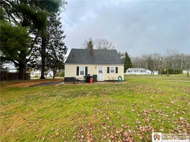 rear view of property with a lawn and a patio