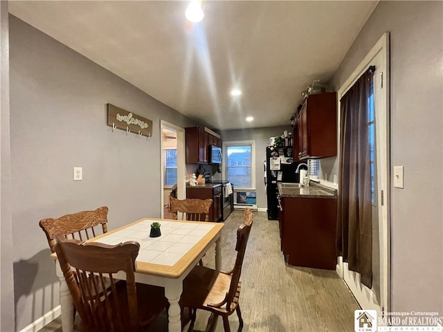 dining area with light hardwood / wood-style floors and sink