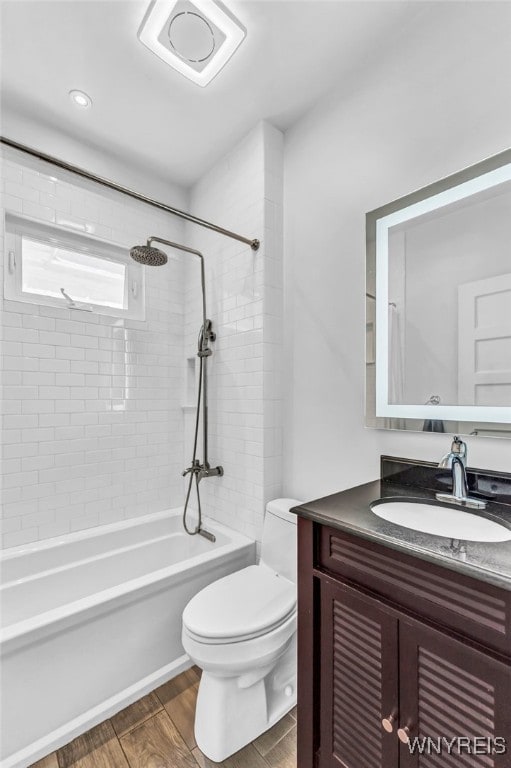 full bathroom featuring wood-type flooring, vanity, toilet, and tiled shower / bath