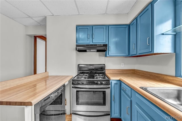 kitchen featuring a drop ceiling, dishwasher, blue cabinets, gas range, and butcher block counters