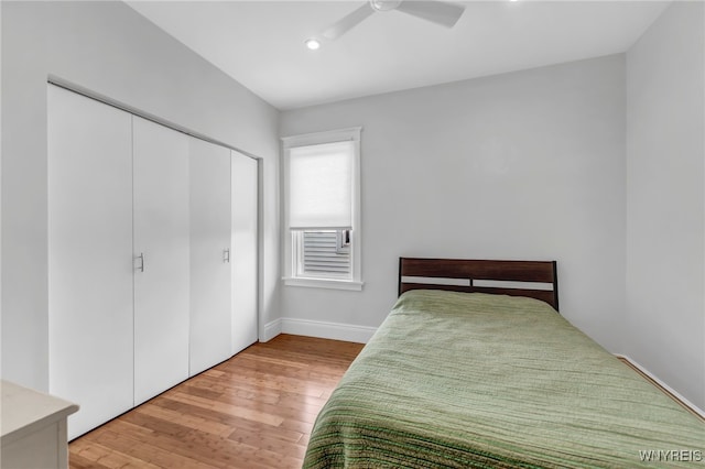 bedroom featuring ceiling fan, a closet, and hardwood / wood-style flooring