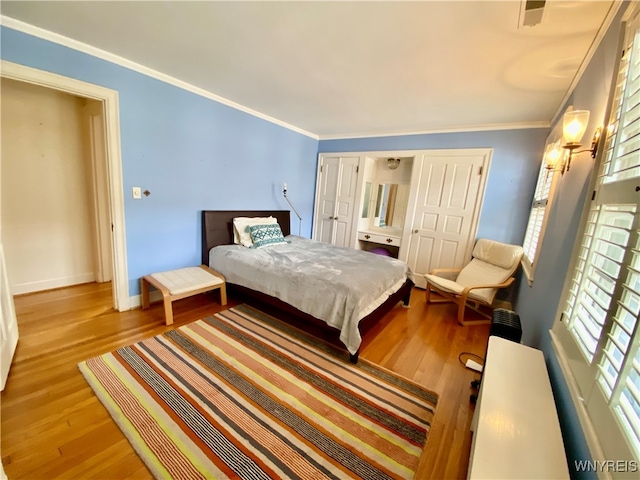 bedroom with ornamental molding and light hardwood / wood-style flooring