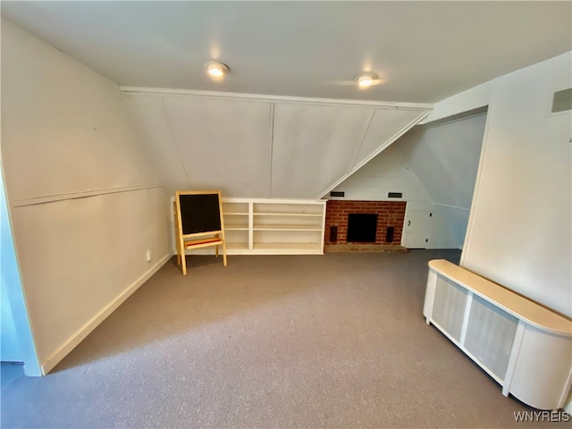 bonus room featuring carpet flooring, a fireplace, radiator heating unit, and lofted ceiling