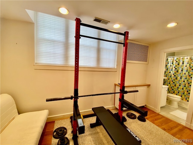 exercise room with light hardwood / wood-style flooring