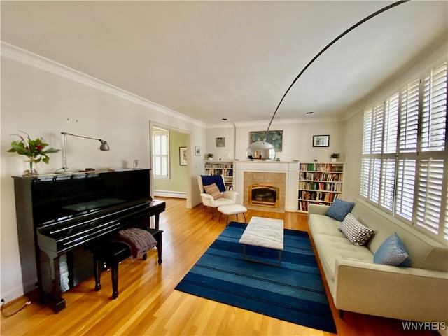 living room featuring hardwood / wood-style floors, ornamental molding, a fireplace, and baseboard heating