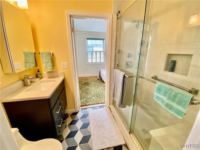 bathroom featuring a shower with door and vanity