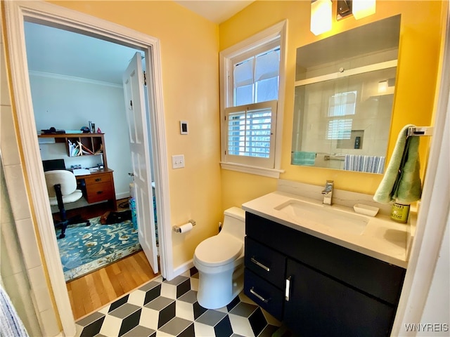 bathroom featuring vanity, crown molding, hardwood / wood-style floors, toilet, and a shower with shower door