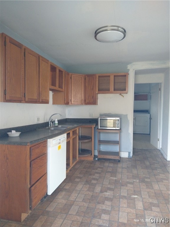 kitchen with sink, white dishwasher, and washer / dryer