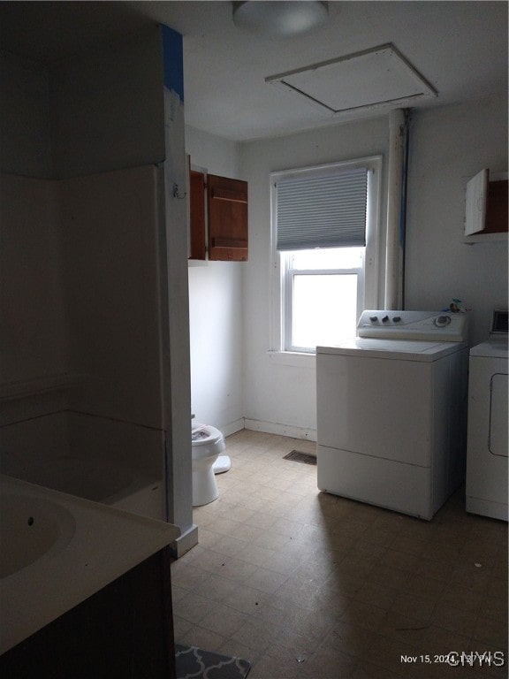 washroom with washing machine and clothes dryer and sink