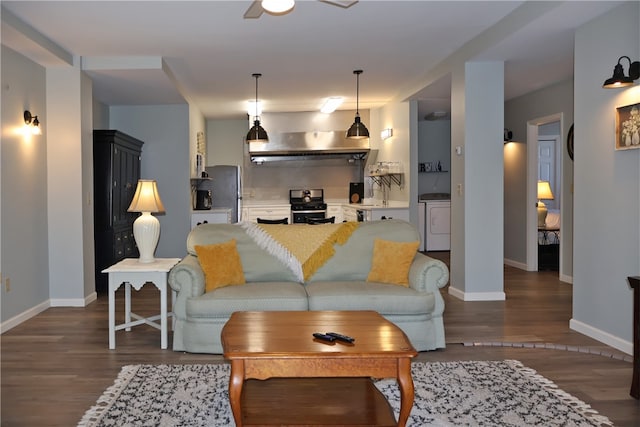 living room featuring separate washer and dryer, ceiling fan, sink, and dark hardwood / wood-style floors