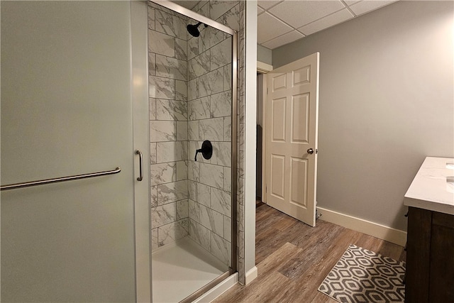 bathroom featuring a paneled ceiling, vanity, wood-type flooring, and walk in shower