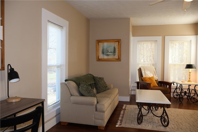 living room with a textured ceiling, ceiling fan, a healthy amount of sunlight, and dark wood-type flooring