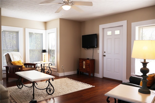 living room featuring a textured ceiling, dark hardwood / wood-style floors, and ceiling fan