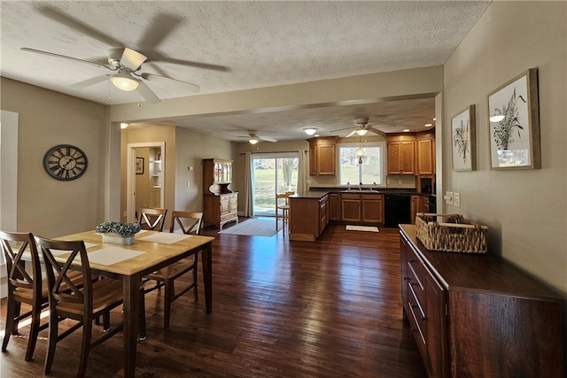 dining space featuring sink, ceiling fan, dark hardwood / wood-style flooring, and a textured ceiling