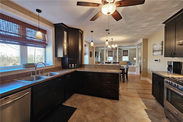 kitchen featuring sink, stainless steel appliances, kitchen peninsula, light hardwood / wood-style floors, and decorative light fixtures