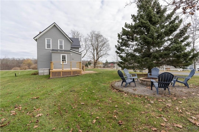 view of yard featuring a deck and an outdoor fire pit