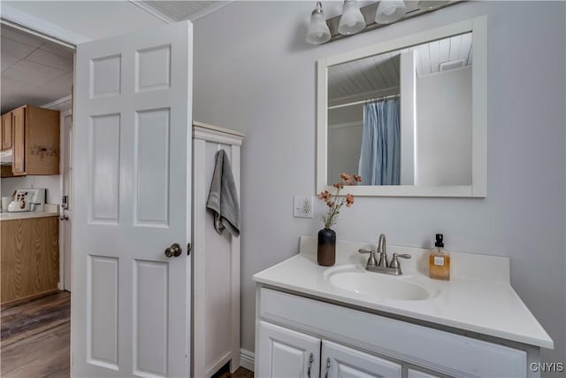 bathroom with a shower with curtain, vanity, wood-type flooring, and crown molding