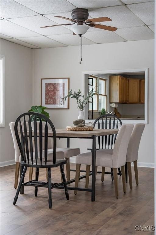 dining space featuring a paneled ceiling, ceiling fan, a healthy amount of sunlight, and hardwood / wood-style flooring