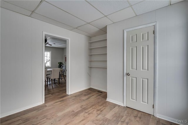 interior space featuring light wood-type flooring and a drop ceiling