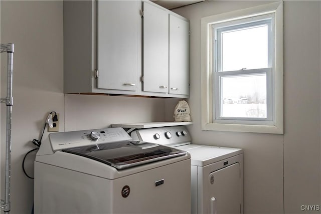 laundry room featuring washer and dryer and cabinets