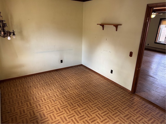 spare room featuring parquet flooring, ceiling fan, and a baseboard heating unit