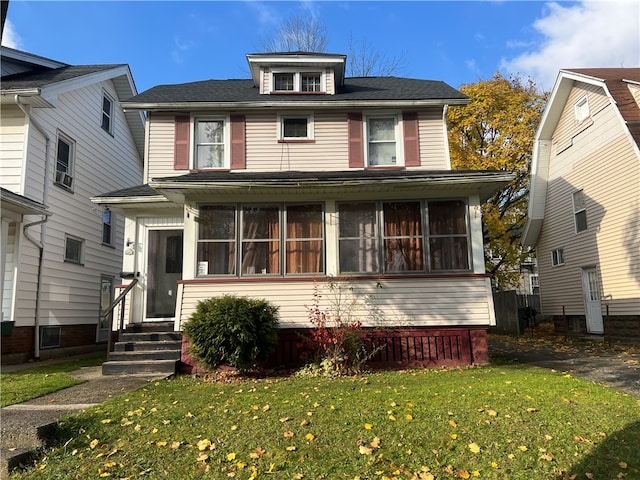 view of front of property featuring a sunroom and a front lawn