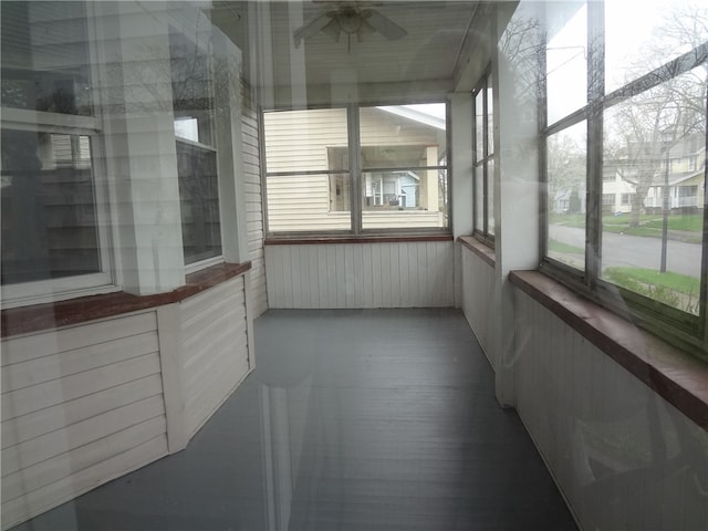 unfurnished sunroom with ceiling fan