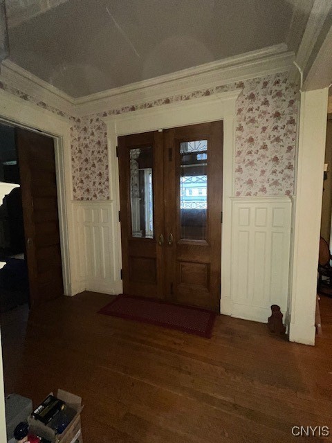 entrance foyer featuring dark hardwood / wood-style flooring, a textured ceiling, and ornamental molding