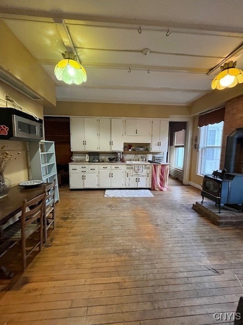 kitchen featuring a wood stove, white cabinets, and light hardwood / wood-style floors