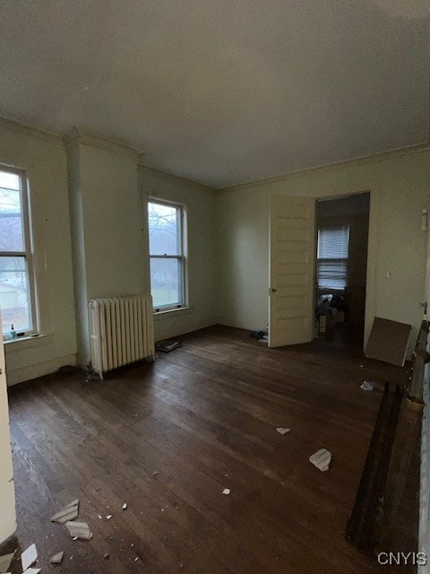 unfurnished living room with radiator, dark hardwood / wood-style flooring, a healthy amount of sunlight, and a textured ceiling