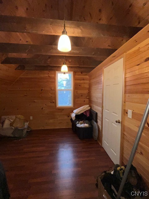 bonus room featuring wooden walls, beamed ceiling, and dark hardwood / wood-style floors