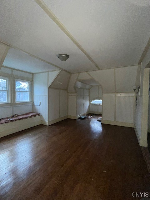 additional living space with dark hardwood / wood-style floors and lofted ceiling