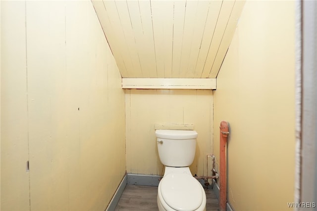 bathroom featuring hardwood / wood-style flooring, toilet, and lofted ceiling