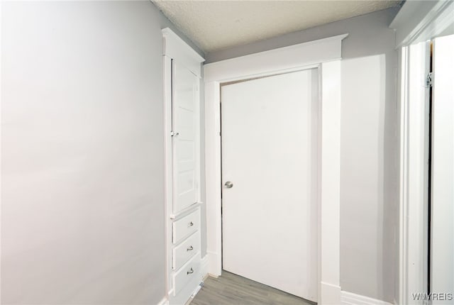 hallway featuring a textured ceiling and light hardwood / wood-style floors