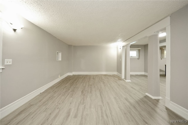 basement with a textured ceiling and light hardwood / wood-style flooring