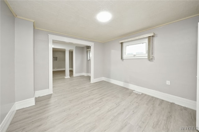 empty room featuring light hardwood / wood-style floors and crown molding