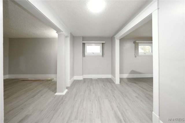 interior space with a healthy amount of sunlight, light wood-type flooring, and a textured ceiling