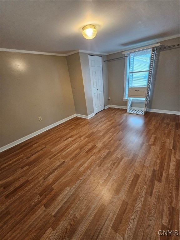 unfurnished bedroom with hardwood / wood-style floors and ornamental molding