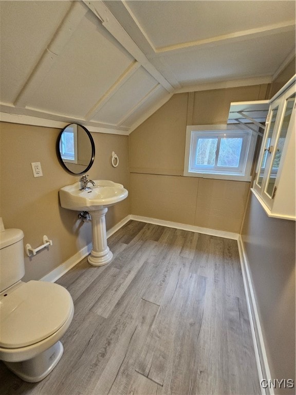 bathroom featuring hardwood / wood-style flooring, toilet, and lofted ceiling