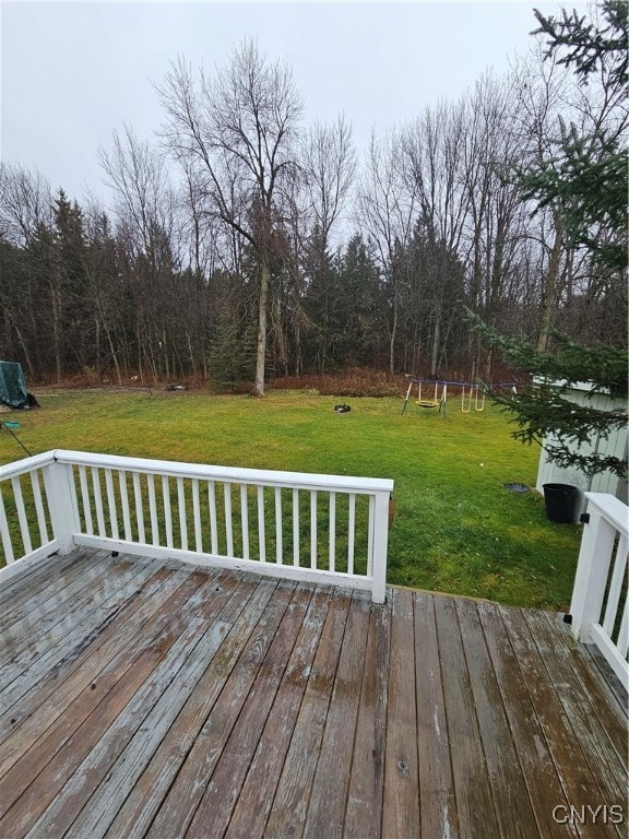 deck with a playground, a yard, and a trampoline