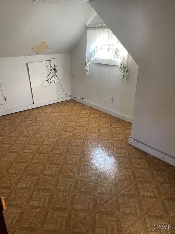 bonus room featuring parquet floors and vaulted ceiling