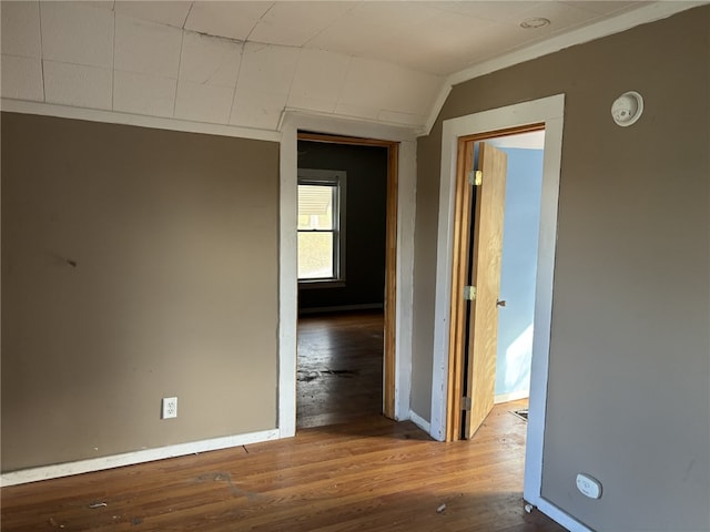 corridor featuring hardwood / wood-style flooring and vaulted ceiling