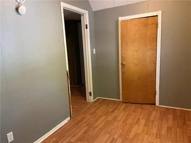 hallway featuring light hardwood / wood-style flooring and vaulted ceiling