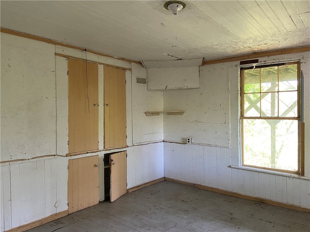 spare room with wood walls and light hardwood / wood-style floors