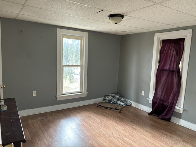 spare room with hardwood / wood-style flooring and a drop ceiling