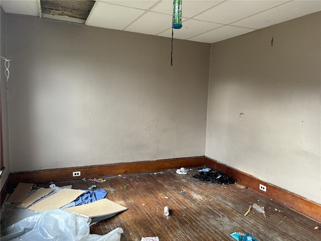 empty room featuring a drop ceiling and wood-type flooring