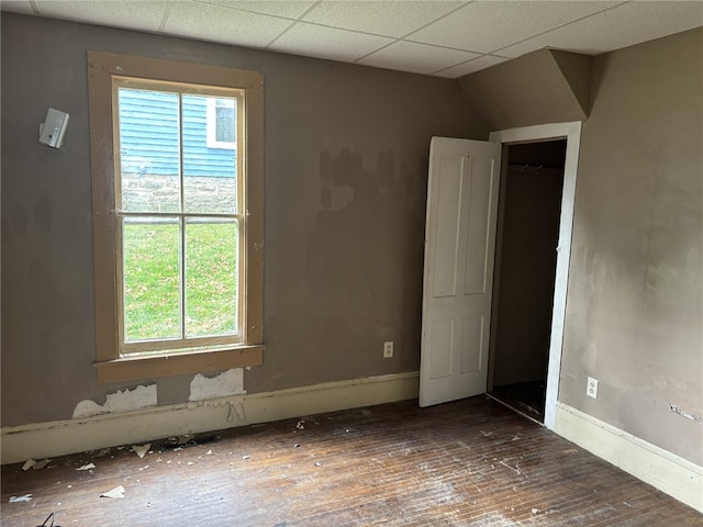 empty room featuring dark hardwood / wood-style flooring and a paneled ceiling