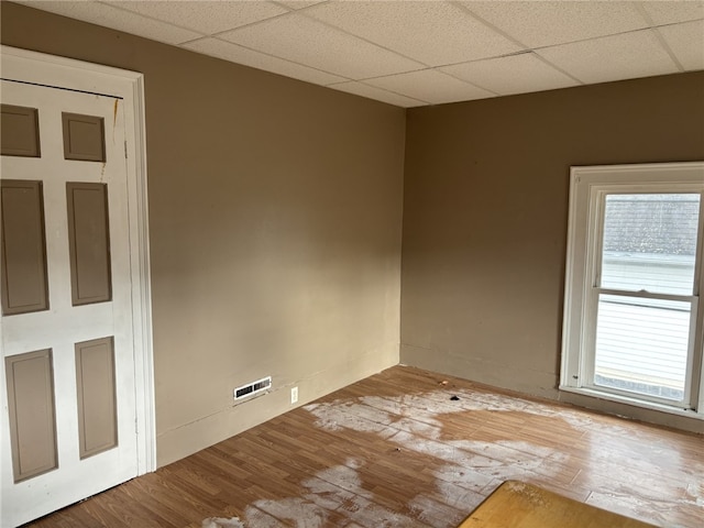 empty room featuring hardwood / wood-style flooring and a drop ceiling