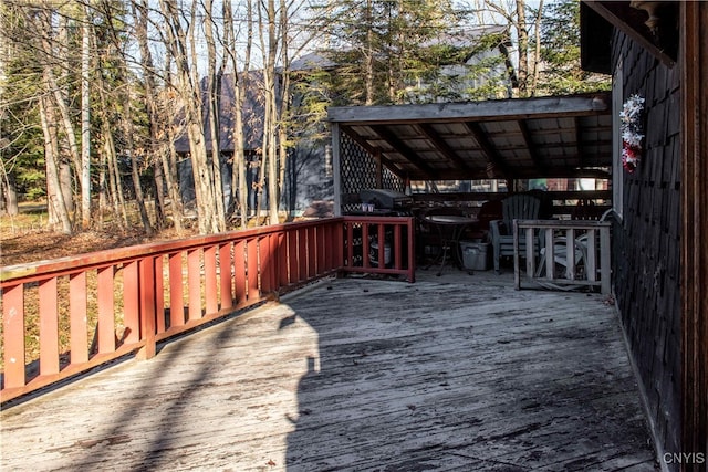 wooden terrace featuring a carport and area for grilling