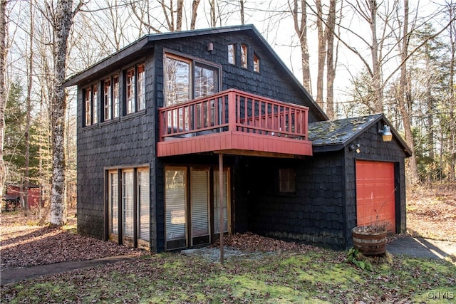 back of house with a garage and a deck